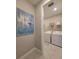 Bright laundry room featuring white washer and dryer, wire shelving, and stylish artwork enhances the functional space at 26017 Seastone Dr, Englewood, FL 34223