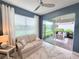 Bright sunroom featuring neutral furniture, sliding glass doors to the lanai, and blue accent wall at 26017 Seastone Dr, Englewood, FL 34223