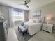 Bright main bedroom featuring a large bed, stylish bench, dresser, and bedside tables with lamps at 26017 Seastone Dr, Englewood, FL 34223