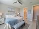 Bright main bedroom featuring a large bed, stylish bench, and ensuite bath with glass shower at 26017 Seastone Dr, Englewood, FL 34223