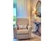 Cozy sitting room with plush chair, accent table, and window providing natural light at 26017 Seastone Dr, Englewood, FL 34223