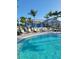 Beautiful swimming pool with surrounding lounge chairs, umbrellas, and lush landscaping for relaxation at 26017 Seastone Dr, Englewood, FL 34223