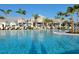 Resort-style swimming pool with ample lounge chairs and palm trees, ideal for relaxation at 26017 Seastone Dr, Englewood, FL 34223