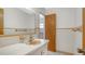 Bathroom features white tile, vintage peach colored fixtures, and a large mirror at 2702 Bedford Way, Sarasota, FL 34239