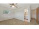 Bedroom with a window, brown carpet, ceiling fan, and doorway to the ensuite bath at 2702 Bedford Way, Sarasota, FL 34239