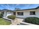 Inviting front entrance with manicured bushes and a stone-paved walkway to the door at 2702 Bedford Way, Sarasota, FL 34239