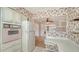 Vintage kitchen with classic refrigerator, stove, and wallpaper, offering a cozy feel at 2702 Bedford Way, Sarasota, FL 34239