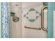 Shower with white and blue tiling and a grab bar for accessibility at 2702 Bedford Way, Sarasota, FL 34239