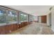 Bright sun room featuring wood paneling, large windows offering plenty of natural light, and neutral carpet at 2702 Bedford Way, Sarasota, FL 34239