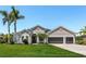 Beautiful single-story home with a manicured lawn and mature palm trees at 3015 160Th E Ter, Parrish, FL 34219