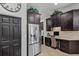 Kitchen with dark wood cabinets, stainless steel fridge, and built-in desk area at 3015 160Th E Ter, Parrish, FL 34219