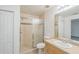 Bathroom featuring a vanity, a toilet, a shower with glass doors, and light-colored tile at 3204 Pericles Ave, North Port, FL 34286