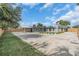 Exterior view of a gray home with a long driveway, lush lawn, and a refreshing pool area at 3312 33Rd Street Ct W, Bradenton, FL 34205