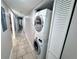 Hallway laundry area with stacked washer and dryer and tiled floors at 3473 Clark Rd # 171, Sarasota, FL 34231