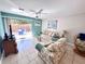 Bright living room with tile floors, ceiling fan, and sliding glass doors to a patio at 3473 Clark Rd # 171, Sarasota, FL 34231