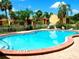 Community pool view with lounge chairs and mature palm trees in a tropical setting at 3473 Clark Rd # 171, Sarasota, FL 34231