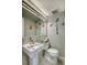 Stylish half bathroom with pedestal sink, decorative wall accents, and a modern mirror fixture at 3701 5Th Ave # 1, Holmes Beach, FL 34217