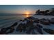 Beautiful sunset view over the beach with rocks and calm waves, capturing the serene landscape at 3701 5Th Ave # 1, Holmes Beach, FL 34217