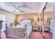 Comfortable bedroom featuring a ceiling fan, accent wall, and mirrored closet at 3701 5Th Ave # 1, Holmes Beach, FL 34217