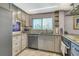 Well-lit kitchen featuring gray cabinets, stainless steel appliances, and a mosaic tile backsplash at 3701 5Th Ave # 1, Holmes Beach, FL 34217