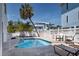 Community pool with stone tile, white fence, and lounge chairs at 3701 5Th Ave # 1, Holmes Beach, FL 34217