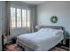 Comfortable bedroom with a large window, wood shutters, and a cozy rug at 3784 Parkridge Cir # 22-203, Sarasota, FL 34243