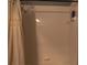 Clean, white tiled shower with a shower curtain, shelving, and showerhead at 3784 Parkridge Cir # 22-203, Sarasota, FL 34243