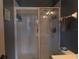 Modern shower behind sliding glass doors with a rain shower head, handheld shower, and built-in shelf at 3784 Parkridge Cir # 22-203, Sarasota, FL 34243