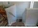 Carpeted stairs leading down, with white railings, chair, and boxes at the top at 3784 Parkridge Cir # 22-203, Sarasota, FL 34243