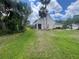 Large backyard features mature landscaping, a screened-in lanai, and healthy green grass at 4111 34Th St E, Bradenton, FL 34208