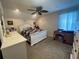A cozy bedroom with neutral walls, plush carpet, a ceiling fan, and natural light at 4111 34Th St E, Bradenton, FL 34208
