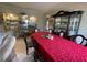 Elegant dining room with glass display cabinets and a large table with red tablecloth at 4111 34Th St E, Bradenton, FL 34208