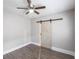 This bedroom features a modern sliding barn door, stylish flooring, and an overhead ceiling fan with light at 4347 9Th N Ave, St Petersburg, FL 33713