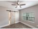 Well-lit bedroom featuring a sliding barn door to the bathroom and wood-look tile flooring at 4347 9Th N Ave, St Petersburg, FL 33713