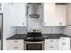 Close up of modern kitchen with granite countertops, stainless steel appliances, white cabinets, and tile backsplash at 4347 9Th N Ave, St Petersburg, FL 33713