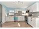 Modern kitchen featuring white cabinets, stainless steel appliances, gray subway tile backsplash, and stylish lighting at 4512 26Th S Ave, Tampa, FL 33619