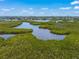 Beautiful aerial view of lush mangroves and tranquil waterways with buildings visible in the distance at 4636 Pine Harrier Dr, Sarasota, FL 34231