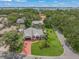 Aerial view of a beautiful home with lush landscaping, a red brick driveway, and a sparkling pool surrounded by greenery at 4636 Pine Harrier Dr, Sarasota, FL 34231