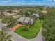 Beautiful home featuring well-manicured landscaping, a circular driveway, and a tile roof in a lush community at 4636 Pine Harrier Dr, Sarasota, FL 34231