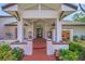 Inviting entryway featuring a brick path, white columns, and lush garden with floral accents at 4636 Pine Harrier Dr, Sarasota, FL 34231