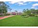 Beautiful home displaying lush lawn, mature trees, brick driveway, and meticulously maintained landscaping at 4636 Pine Harrier Dr, Sarasota, FL 34231