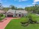 Charming single-story home boasting well-manicured lawn, brick driveway, and lush tropical landscaping at 4636 Pine Harrier Dr, Sarasota, FL 34231