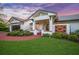 Stunning home exterior with well-maintained landscaping, a brick walkway, and a welcoming porch enhanced with hanging plants at 4636 Pine Harrier Dr, Sarasota, FL 34231