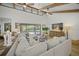 Cozy living room with view to backyard pool area, vaulted ceilings, and exposed wood beams at 4636 Pine Harrier Dr, Sarasota, FL 34231