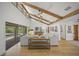Bright living room with vaulted ceilings, wood beams, and sliding glass doors to the pool at 4636 Pine Harrier Dr, Sarasota, FL 34231
