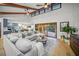 Bright living room with vaulted ceilings, exposed beams, a comfortable sofa, and sliding glass doors to the outdoor patio at 4636 Pine Harrier Dr, Sarasota, FL 34231