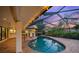 Inviting in-ground pool with a screened enclosure, brick paving, lush landscaping, and ample space for outdoor entertaining at 4636 Pine Harrier Dr, Sarasota, FL 34231