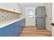 Bright laundry room with blue lower cabinets, a white countertop, and a stacked washer and dryer at 4812 21St W St, Bradenton, FL 34207
