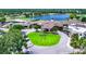 Stunning aerial view of the community clubhouse surrounded by lush landscaping and a serene lake at 5217 Chase Oaks Dr, Sarasota, FL 34241