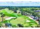 Aerial view of golf course features lush greens, sand traps, palm trees, and golf carts at 5217 Chase Oaks Dr, Sarasota, FL 34241